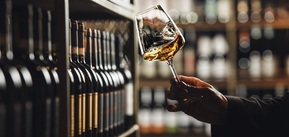 Close-up,Of,Sommelier,Tasting,White,Wine,In,Dimly,Lit,Cellar